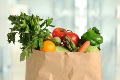 Fresh produce in paper grocery bag inside kitchen